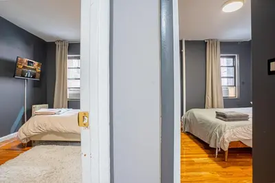 a room with two beds and a room with a door at Stylish 3BD Near Empire in New York