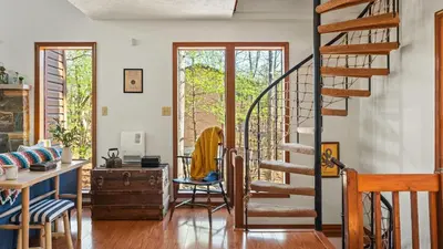 a living room with a spiral staircase and a desk at Pirate-Themed Lakefront Home w Kayaks Game Room Views Hidden Treasure Hunt in East Stroudsburg