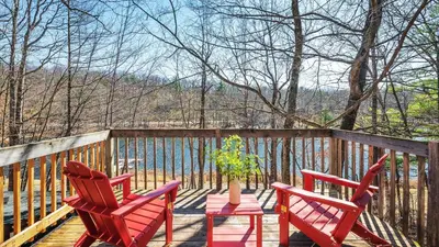 two red chairs and a potted plant on a deck at Pirate-Themed Lakefront Home w Kayaks Game Room Views Hidden Treasure Hunt in East Stroudsburg