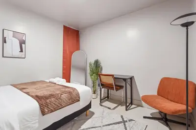 a bedroom with a bed and a desk and a chair at 5BD Duplex w Private Patio BBQ and Arcade Games in Brooklyn