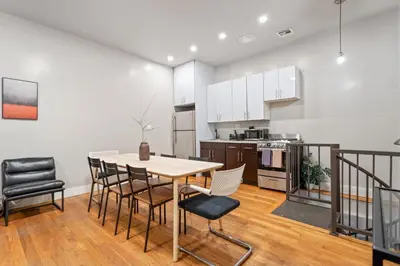 a kitchen and dining room with a table and chairs at 5BD Duplex w Private Patio BBQ and Arcade Games in Brooklyn