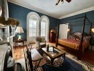 a bedroom with a bed and a living room at The Stone House in Sharon Springs