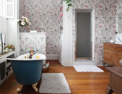 a bathroom with a blue bath tub and floral wallpaper at The Stone House in Sharon Springs