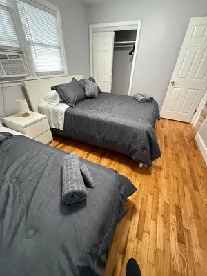 a bedroom with two beds and a wooden floor at MetLife 10 Min 8 Guests Free Parking in Jersey City