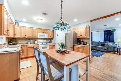 a kitchen with wooden cabinets and a wooden table with chairs at Less Than 1 Mi to Main St Rural Gem in Cherry Valley in Cherry Valley