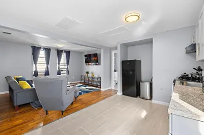 a kitchen and living room with a couch and a table at Peaceful Hideaway - NYC & NWK with free parking in Newark