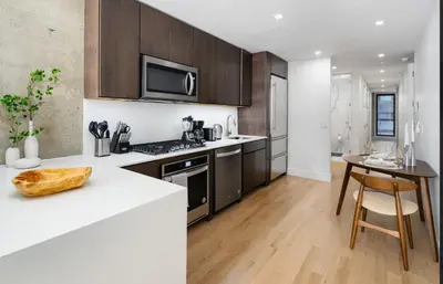 a kitchen with a white counter top and wooden cabinets at Stunning Apartment in Manhattan with Patio in New York
