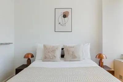 a bedroom with a white bed with two lamps at Blueground Battery Park City rooftop nr Hudson River NYC-291 in New York