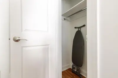 a black tie hanging in a closet next to a door at Blueground Upper West Side wd nr Central Park NYC-1860 in New York