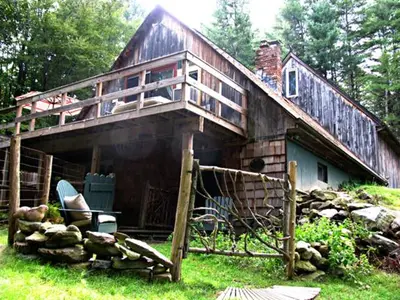 a large wooden house with a balcony on top of it at Owl's Nest Lodging