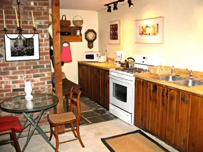 a kitchen with a table and a stove and a sink at Owl's Nest Lodging