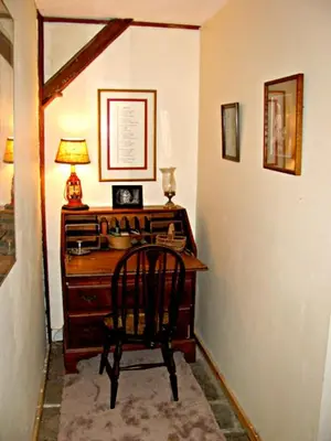 a desk with a chair and a lamp in a room at Owl's Nest Lodging