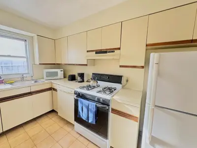 a small kitchen with a stove and a refrigerator at Spacious and Convinient near NYC Parking Available in Guttenberg
