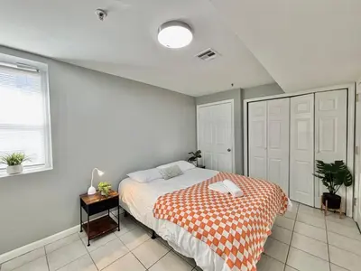 a bedroom with a bed with an orange and white blanket at FREE Parking Cozy 2 Bedroom unit near NYC in North Bergen