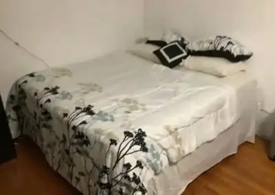 a bedroom with a bed with a white comforter at sarah suite in Mount Vernon