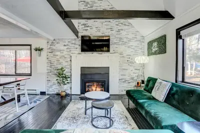 a living room with a green couch and a fireplace at Modern 4 Bedroom Home with Sauna and Game Room in Gated Lake Community in East Stroudsburg