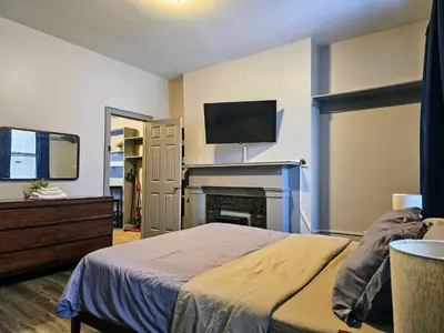 a bedroom with a bed and a tv and a fireplace at Massive 5BD/4BA 3-Story Duplex @ Downtown Albany in Albany