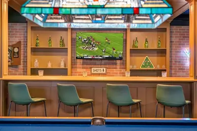 a bar with four chairs and a tv on the wall at 5BR Lux Cabin w HotTub Sauna Pool FirePit GameRoom in East Stroudsburg