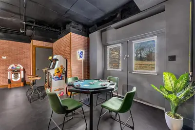 a dining room with a table and green chairs at 5BR Lux Cabin w HotTub Sauna Pool FirePit GameRoom in East Stroudsburg