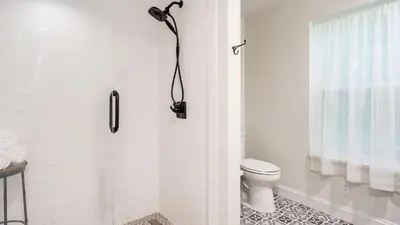 a white bathroom with a shower with a toilet at Pondfront Gem Minutes from Hudson’s Best Shops Cafes The Stillwater House in Hudson