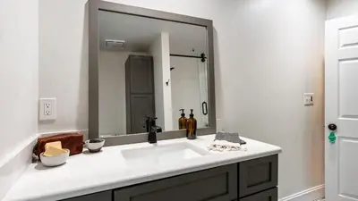 a bathroom with a sink and a large mirror at Pondfront Gem Minutes from Hudson’s Best Shops Cafes The Stillwater House in Hudson