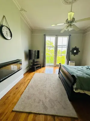 a bedroom with a bed and a clock and a tv at Charming, Spacious Apartment Downtown Albany in Albany