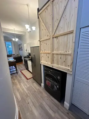 a kitchen with a washer and dryer under a wooden wall at Charming, Spacious Apartment Downtown Albany in Albany