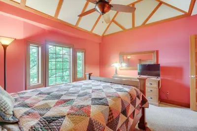 a bedroom with a large bed and a television at Luxe Family Home on Orange Lake with Private Dock! in Newburgh
