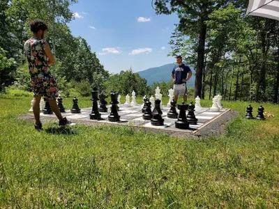 two people standing in front of a giant chessboard at House 15 mins from Woodstock NY with stunning views in Shokan