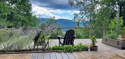 two black chairs sitting on a deck with a view at House 15 mins from Woodstock NY with stunning views in Shokan