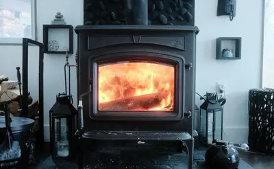 a stove with a fire in a living room at House 15 mins from Woodstock NY with stunning views in Shokan