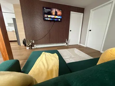 a living room with a green couch and a tv at 15 mins to NYC-Great Apartment Great for Family in West New York