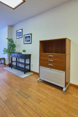 a large dresser in a room with a desk at The Luxe Loft in Long Island City