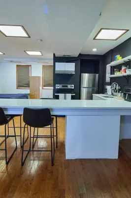 a kitchen with a blue counter and two chairs at The Luxe Loft in Long Island City