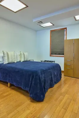 a bedroom with a blue bed and a wooden floor at The Luxe Loft in Long Island City