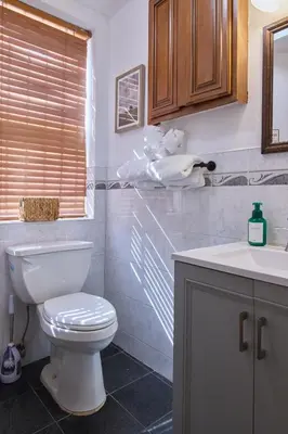 a bathroom with a white toilet and a sink at The Luxe Loft in Long Island City