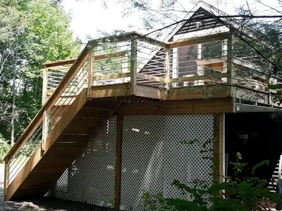 a tree house with a staircase on top of it at Apartment on the Battenkill River in Greenwich