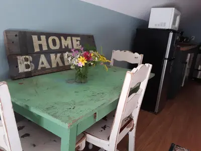 a green table with a vase of flowers on it at Apartment on the Battenkill River in Greenwich