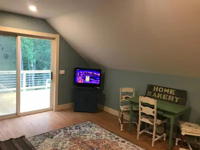 a living room with a table and a tv and a table and chairs at Apartment on the Battenkill River in Greenwich