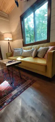 a living room with a couch and a window at Tiny House on the Battenkill River in Greenwich