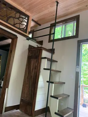 a ladder leading up to a loft in a tiny house at Tiny House on the Battenkill River in Greenwich