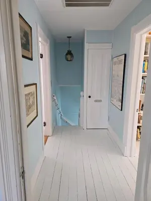a hallway with blue walls and a white door at Captain Tiffany's in Saugerties