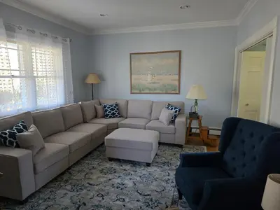 a living room with a sectional couch and a chair at Captain Tiffany's in Saugerties
