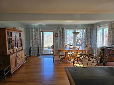 a dining room and living room with a table and chairs at Captain Tiffany's in Saugerties