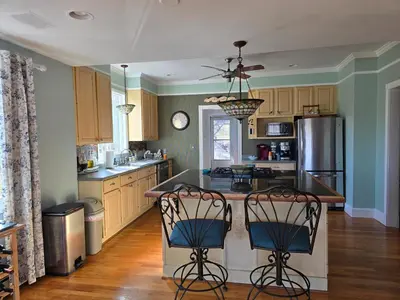 a kitchen with a island with two chairs in it at Captain Tiffany's in Saugerties