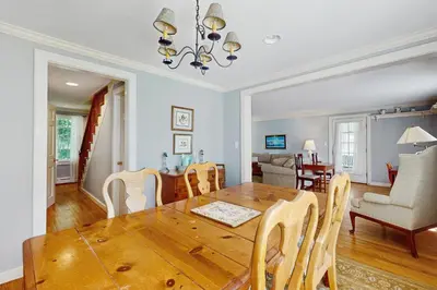 a dining room and living room with a table and chairs at The Village House in Manchester