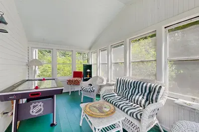 a room with a table and chairs and windows at The Village House in Manchester