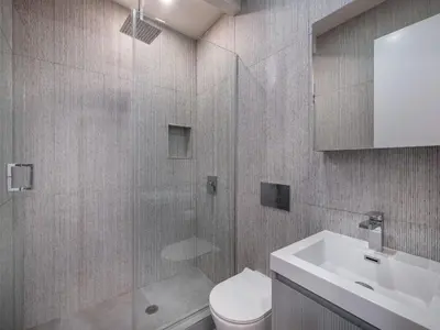 a bathroom with a shower and a toilet and a sink at Condo-Hotel near Bedford Ave L-Subway in Brooklyn