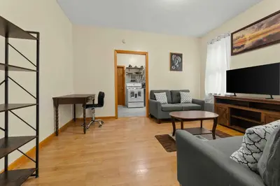 a living room with a couch and a television at Immaculate furnished 1-Bedroom Apartment in Sunnyside