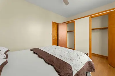 a bedroom with a bed with a blanket on it at Immaculate furnished 1-Bedroom Apartment in Sunnyside